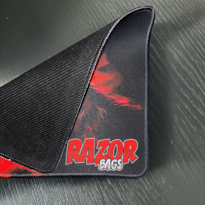 Black mousepad with red and white design featuring 'RAZOR BAGS' on a textured gray background