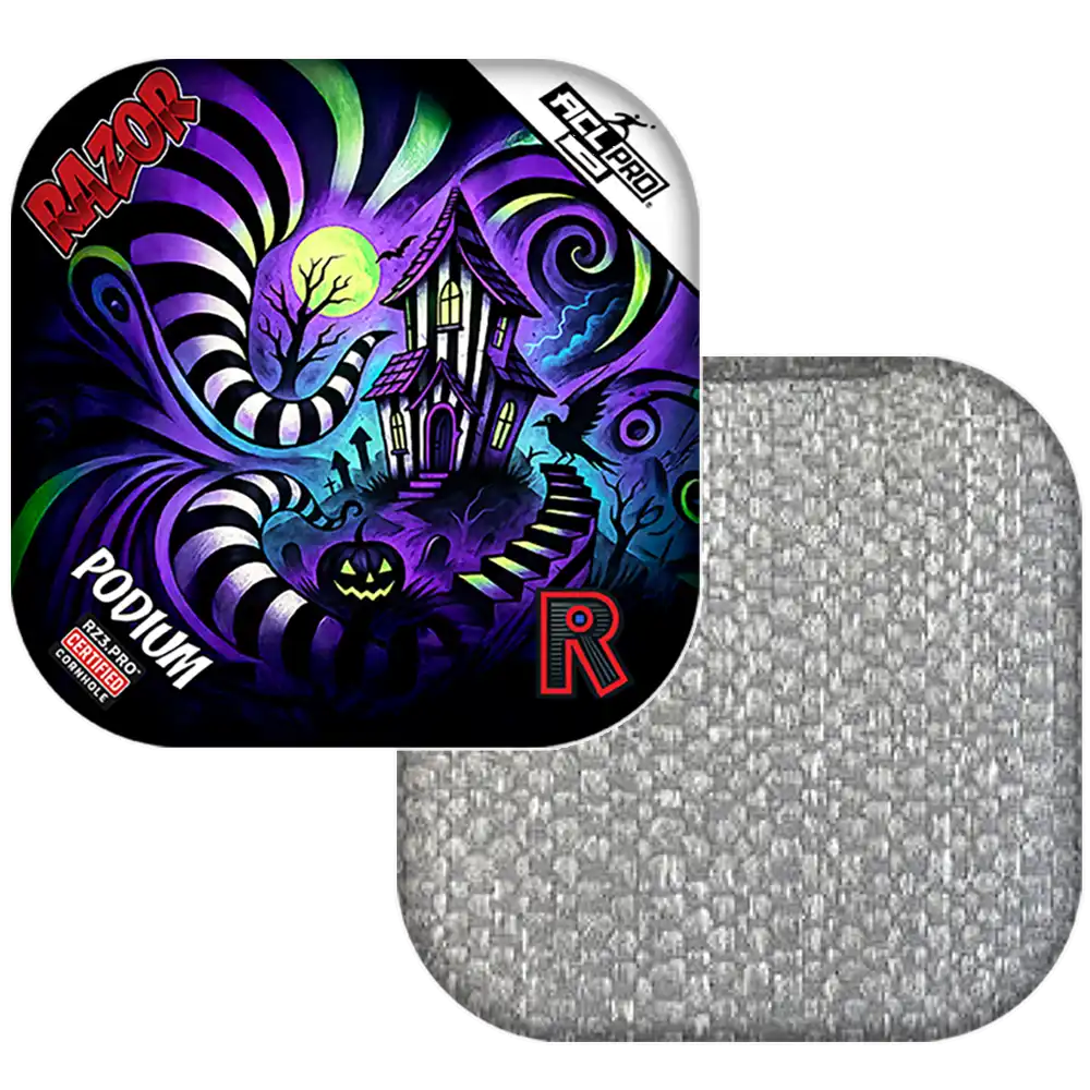 Colorful cornhole bag with a haunted house design and Razor branding, next to a gray textured square.