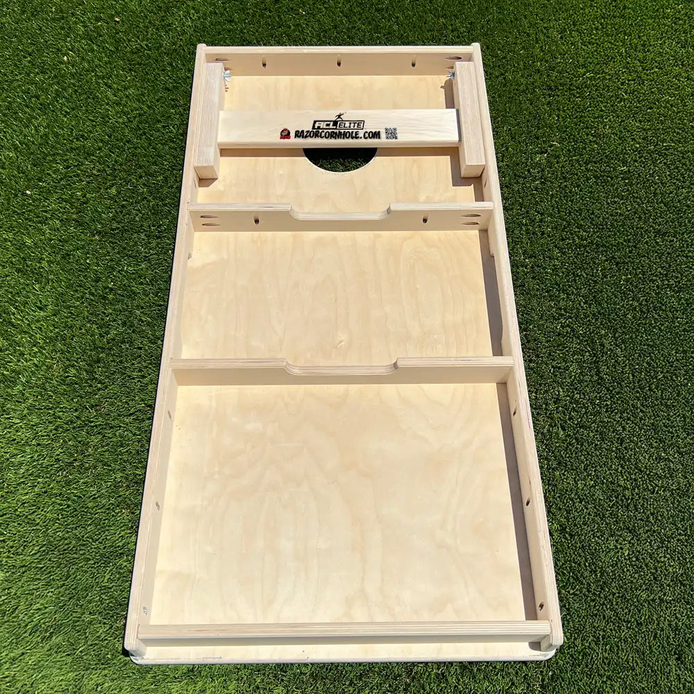 Wooden cornhole board on a grassy background